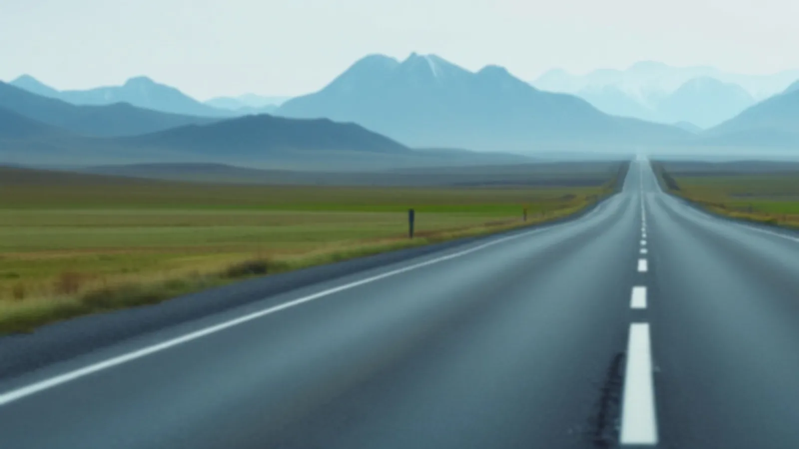An empty road across open green tundra toward distant blue mountains under a wide pale sky, the CoupeYield view of online loans for all credit types, $100 – $5,000